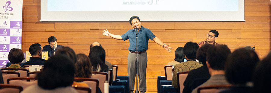 テリトリー(原題Teritoryo)という詩を朗読しているのパオロ氏と観客の後ろ姿の写真